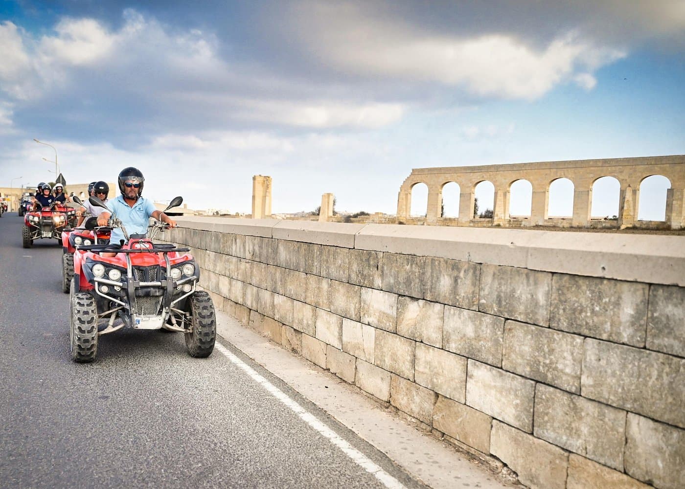 Riders on quads exploring Gozo in late light.