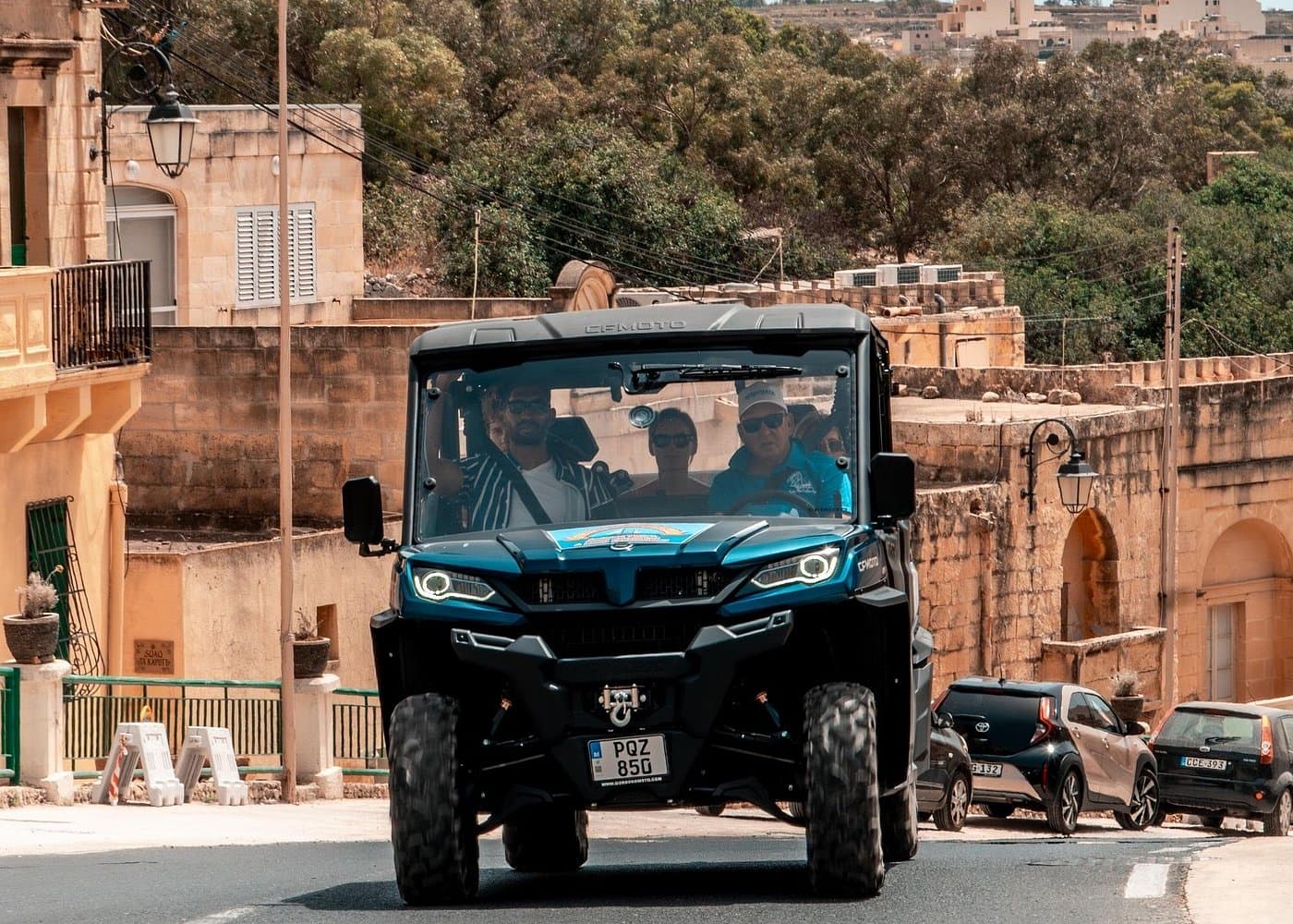 Chauffeured 4WD buggy leaving a Gozo village street with a driver-guide.